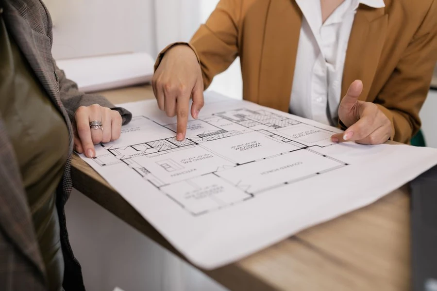 Hände über einem Küchen-Grundrissplan bei der Küchenplanung