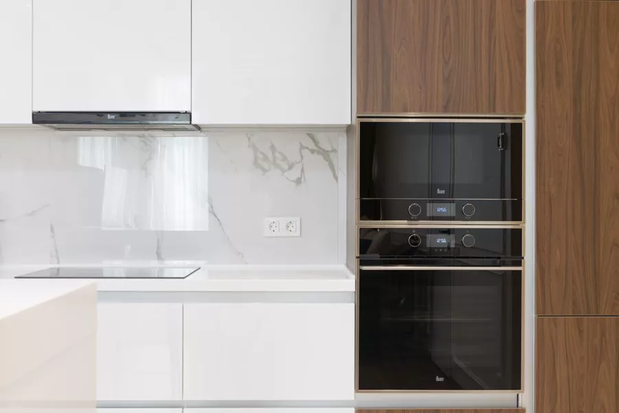 Moderne Einbauküche mit integrierten Elektrogeräten wie Backofen und Kochfeld